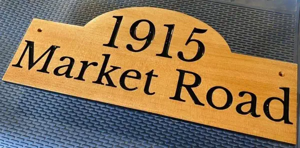 Finished maple house sign with black 1915 Market Road lettering and a curved top