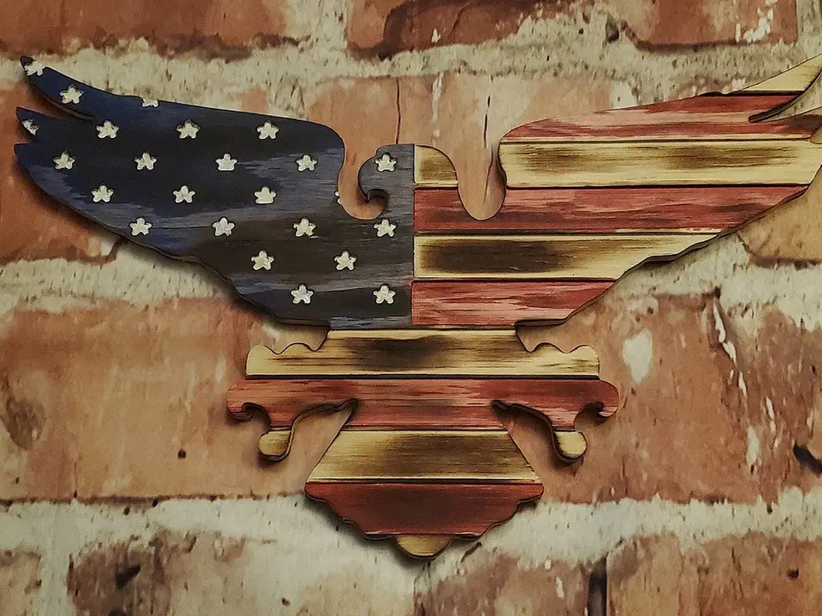 Carved American flag with a blue star field and red-and-natural stripes forming an eagle silhouette