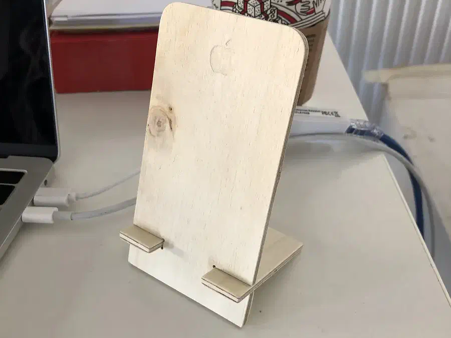 Two-piece plywood phone stand with a tall rounded back and a slotted support